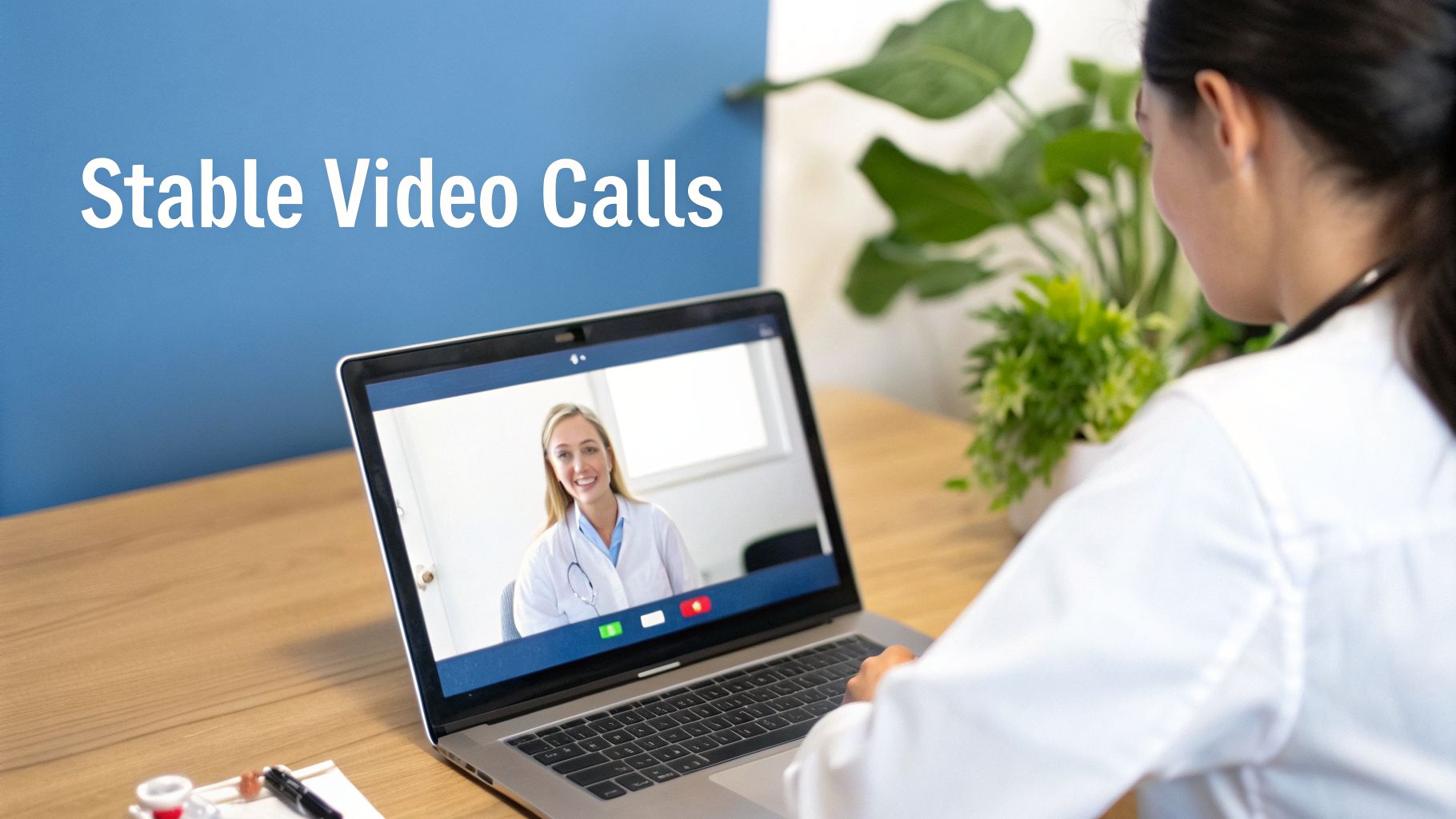 A female doctor participates in a stable video call with another doctor on a laptop.