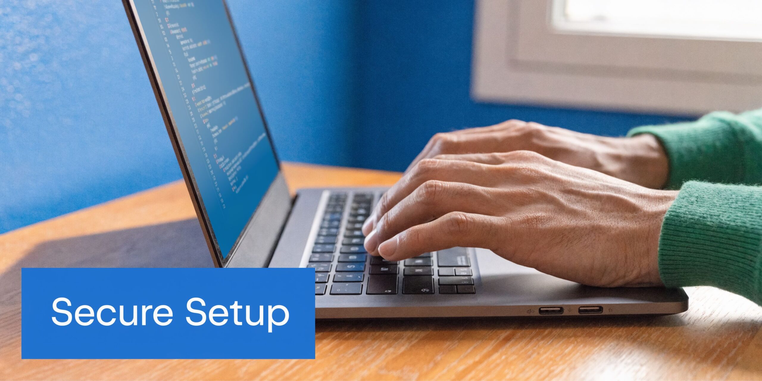 A close-up view of hands typing on a laptop keyboard with code visible on the screen