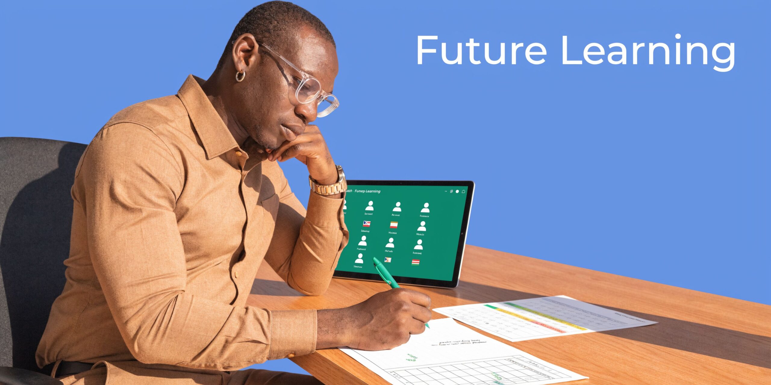 A focused man wearing glasses and a tan shirt writing on paper while using a tablet for education.