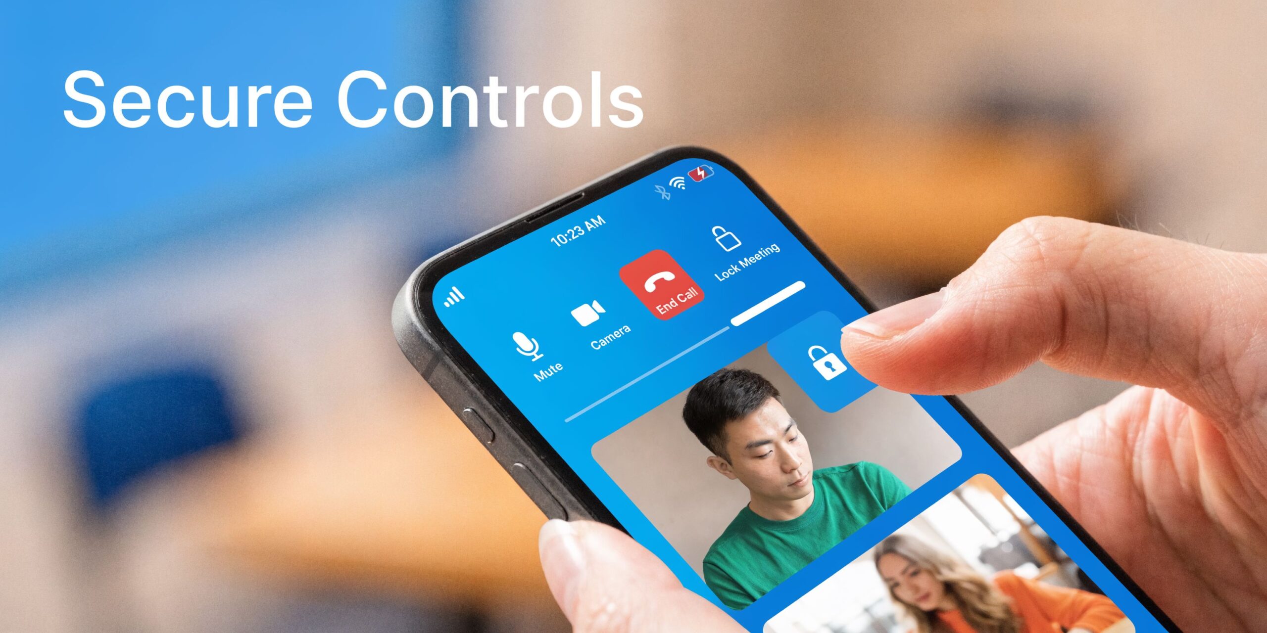 A hand holding a smartphone showing a video conferencing app with secure meeting control features displayed.